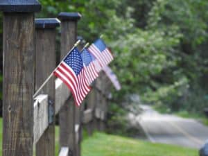 Tiny American flags on a wooden fence